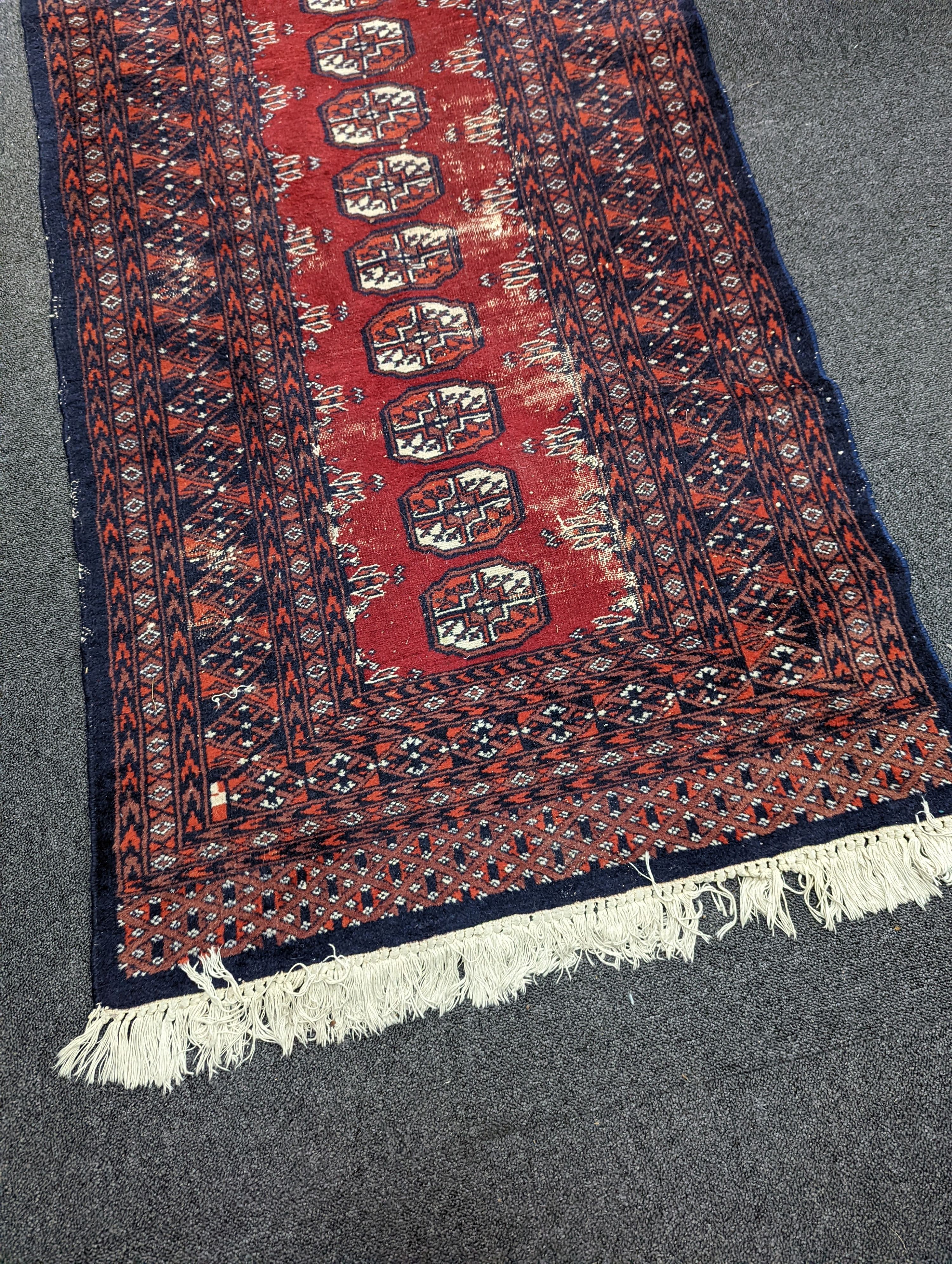 A Caucasian red ground rug and a Bokhara runner, rug 180 x 120 cms